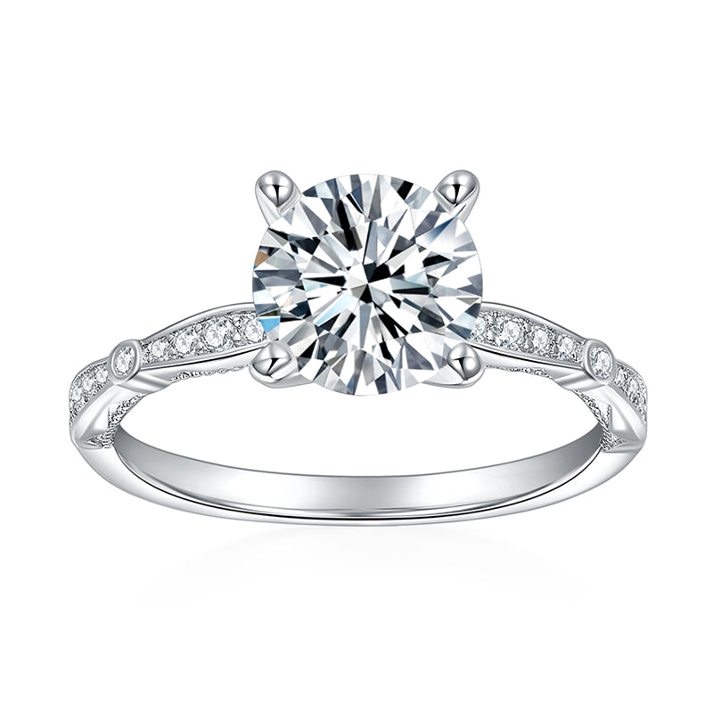 CARISSIE round moissanite solitaire ring, front view displaying four-prong setting and milgrain details on silver-tone metal