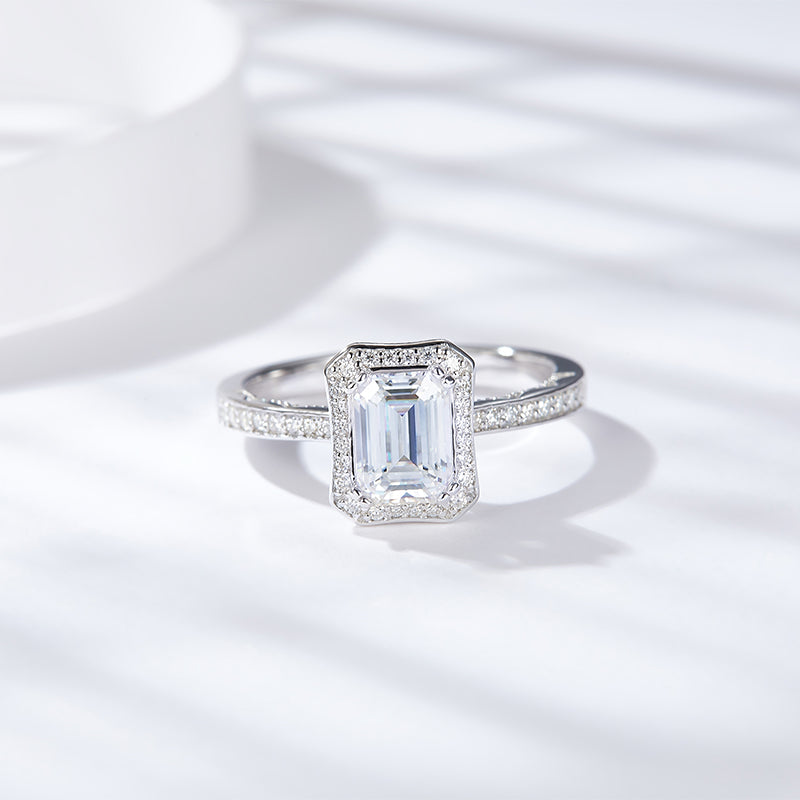 CARISSIE emerald cut moissanite halo ring, front view displaying rectangular center stone and double halo on white background