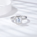 CARISSIE emerald cut moissanite halo ring, front view displaying rectangular center stone and double halo on white background