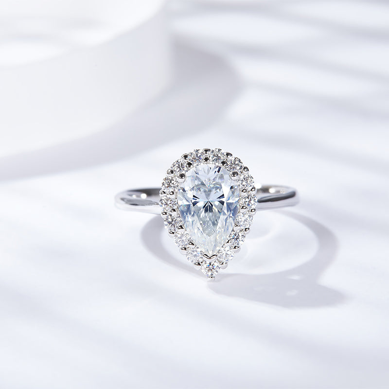 CARISSIE pear moissanite halo ring, top-down view highlighting the brilliant center stone and surrounding diamond halo on a white background