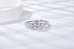 CARISSIE round moissanite solitaire ring, angled view capturing brilliant fire of center stone and side gems