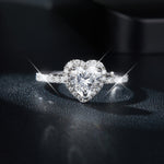 CARISSIE heart moissanite halo ring, front view showing brilliant center stone and pavé band on dark surface