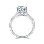 CARISSIE round moissanite solitaire ring, side profile revealing gallery structure and half-pavé accent stones along the inner band