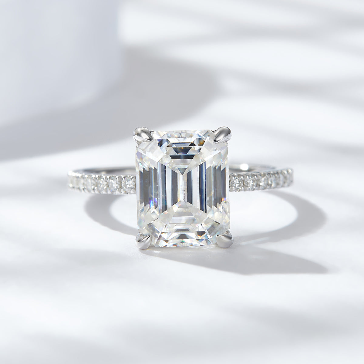 CARISSIE emerald cut solitaire engagement ring, front view displaying rectangular moissanite and four prongs