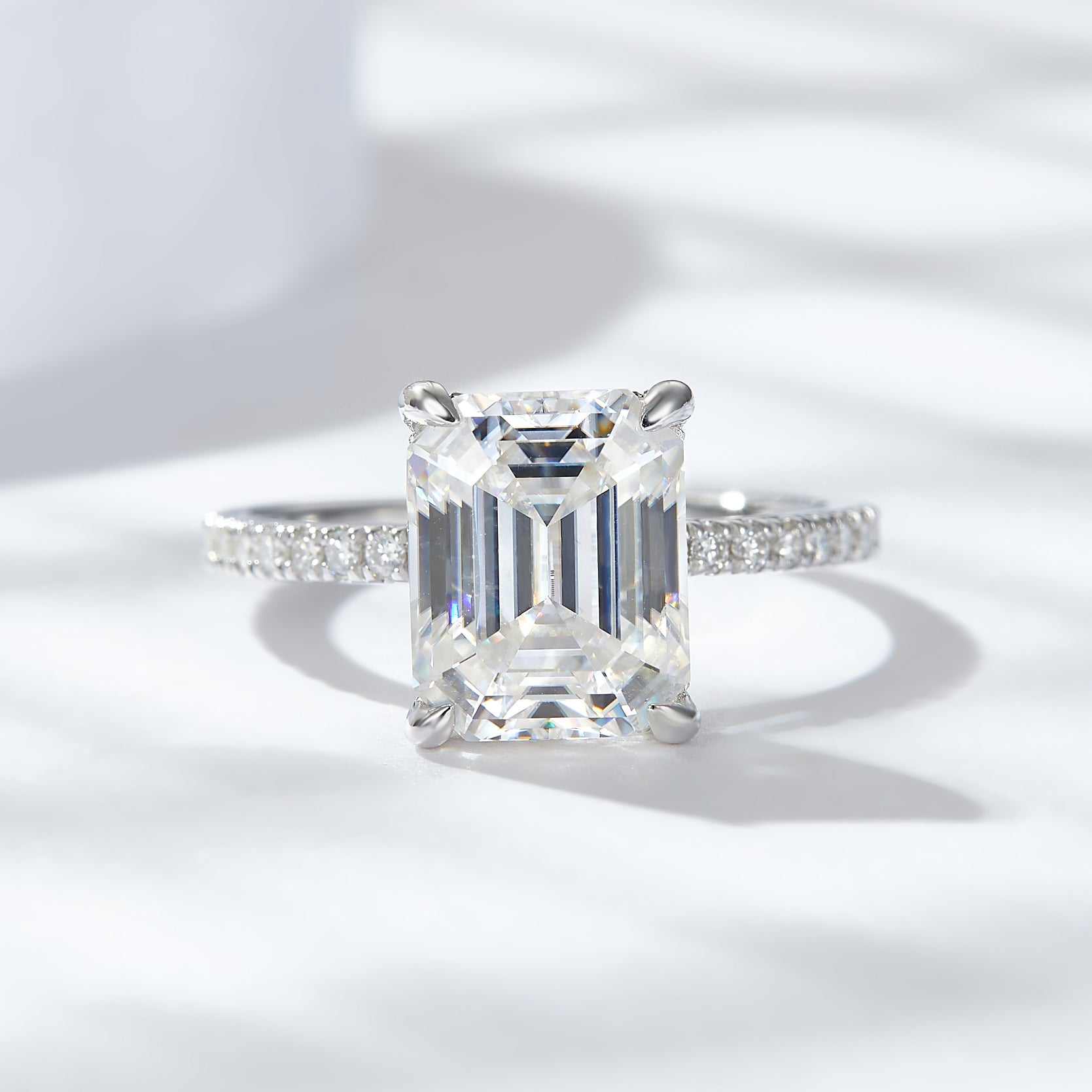 CARISSIE emerald cut solitaire engagement ring, front view displaying rectangular moissanite and four prongs