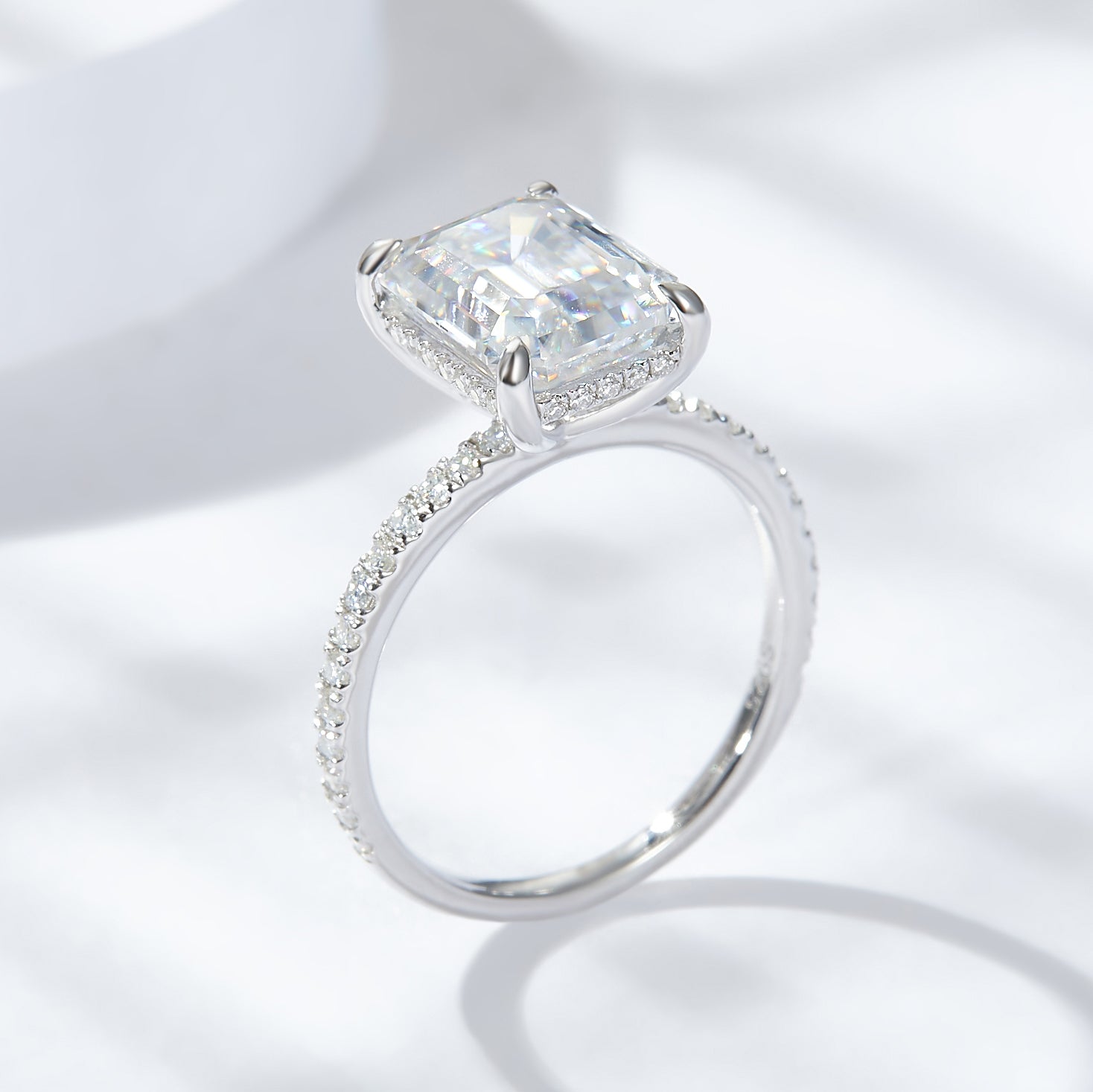 CARISSIE emerald cut solitaire engagement ring, side profile showing high setting and continuous pavé stones