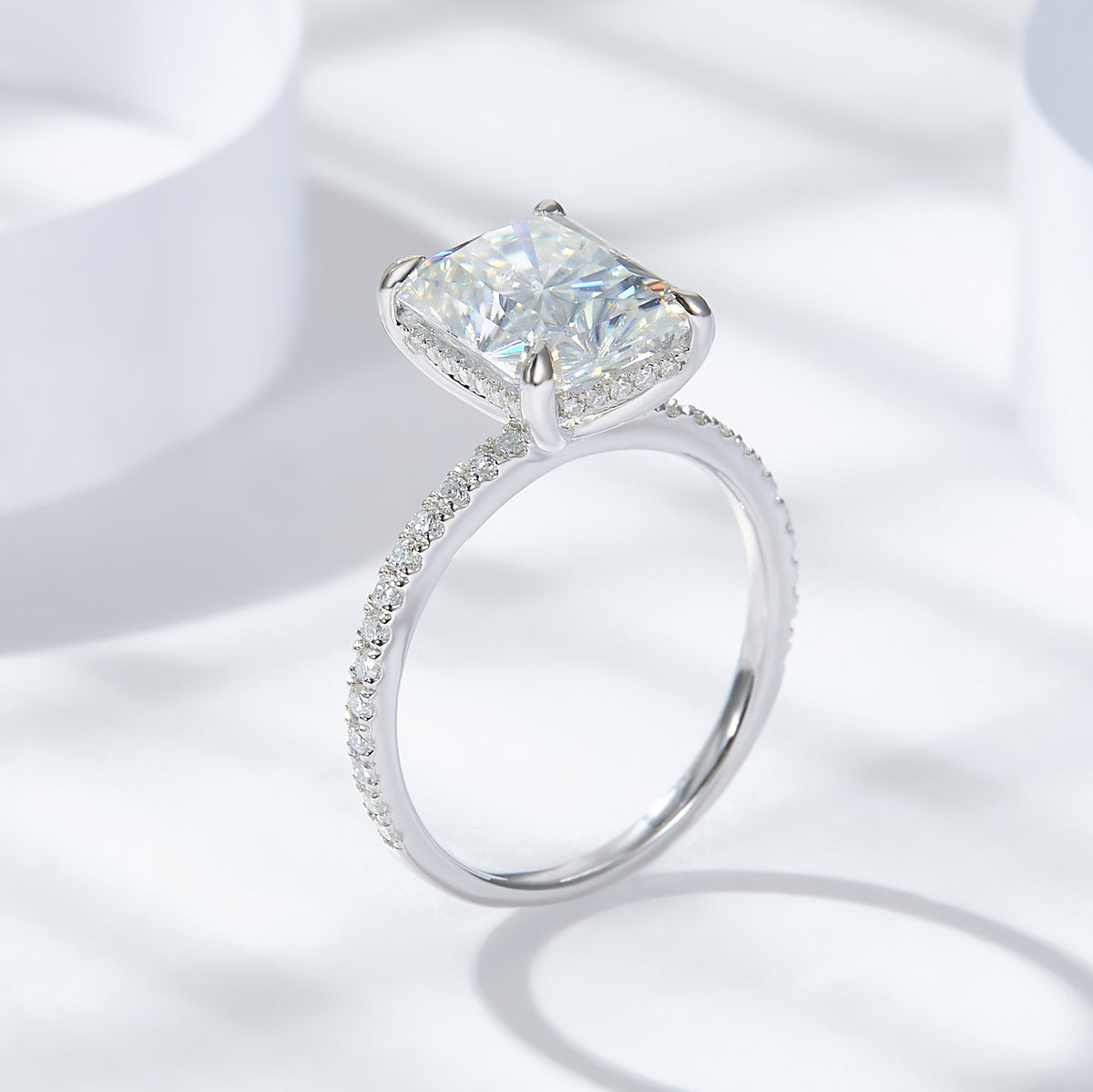 CARISSIE radiant solitaire engagement ring, angled view highlighting the pavé band and four prong setting