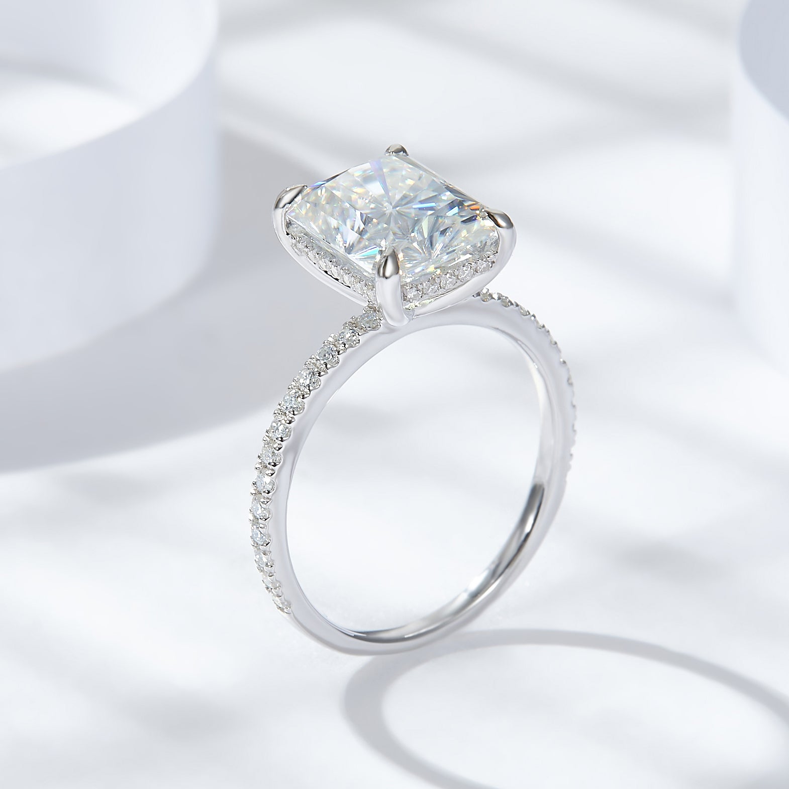 CARISSIE radiant solitaire engagement ring, angled view highlighting the pavé band and four prong setting