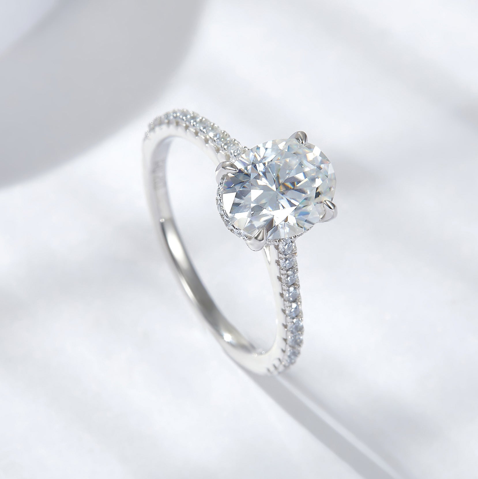 CARISSIE oval moissanite solitaire ring, angled top-down view highlighting brilliant facets of the gemstone and delicate prongs