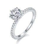 CARISSIE round moissanite solitaire ring, angled view highlighting the brilliant center stone and pavé band details