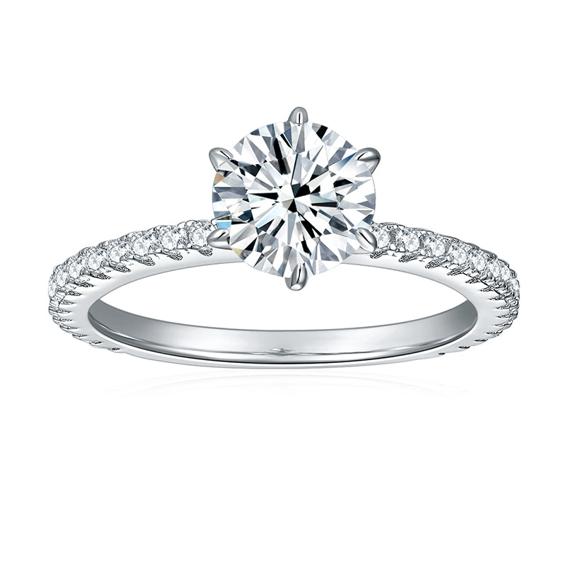 CARISSIE round moissanite solitaire ring, front view showing the classic four-prong setting and sparkling diamond accents