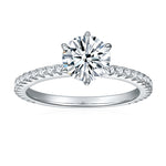 CARISSIE round moissanite solitaire ring, front view showing the classic four-prong setting and sparkling diamond accents