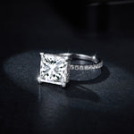 CARISSIE princess solitaire engagement ring, low-angle close-up capturing brilliant facets and silver-tone metal finish