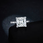 CARISSIE princess solitaire engagement ring, straight-on shot resting on black display box showcasing center gem