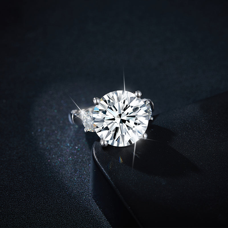 CARISSIE round moissanite solitaire ring, dramatic lighting close-up capturing the brilliance of the main stone against a black surface