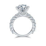 CARISSIE round moissanite engagement ring, side profile revealing twisted band with bezel-set accent stones and pavé gallery