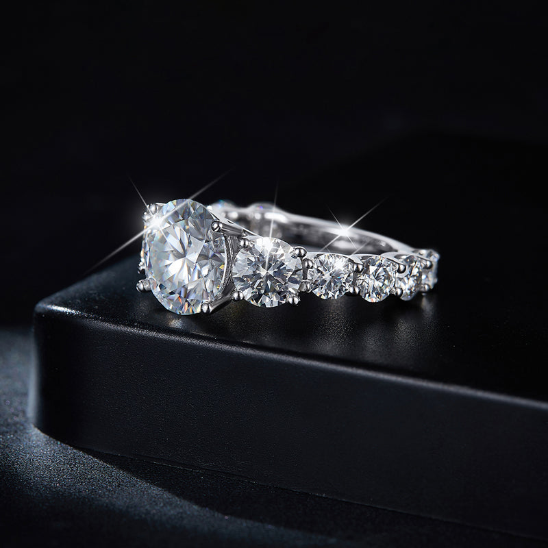 CARISSIE round moissanite solitaire ring, lifestyle image resting on a black box to emphasize the high-profile silhouette and fire