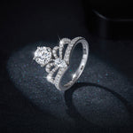 CARISSIE round moissanite solitaire ring, three-quarter view showing the full diamond-encrusted band and prong setting