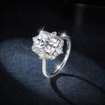 CARISSIE radiant moissanite halo engagement ring, dramatic lighting capturing sparkle on dark background