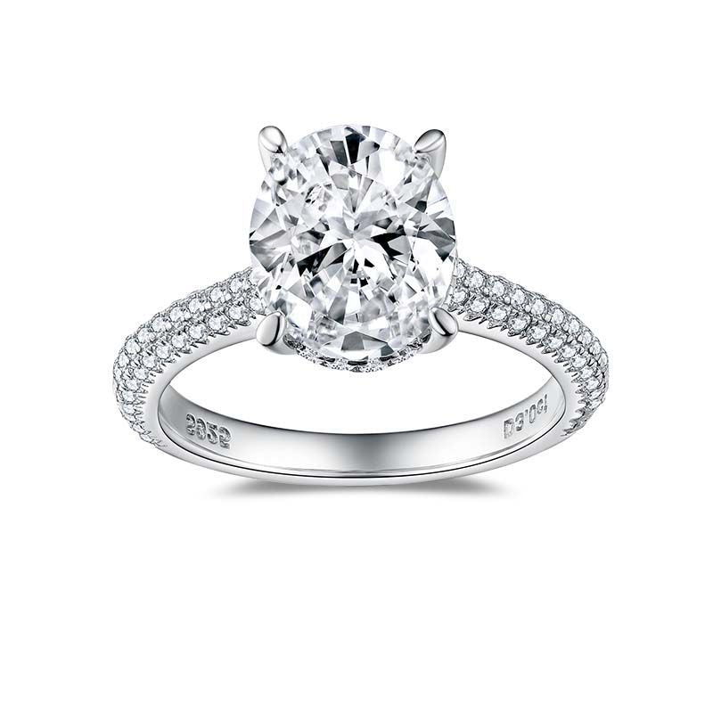 CARISSIE oval moissanite solitaire ring, front view displaying the four-prong setting and symmetrical diamond-encrusted band