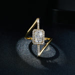 CARISSIE radiant solitaire engagement ring, angled shot on dark textured background highlighting stone sparkle and gold finish