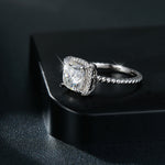 CARISSIE cushion solitaire engagement ring, lifestyle shot resting on a black box with light reflections