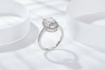CARISSIE oval moissanite solitaire ring, side profile on white display revealing gallery structure and pavé shoulder stones
