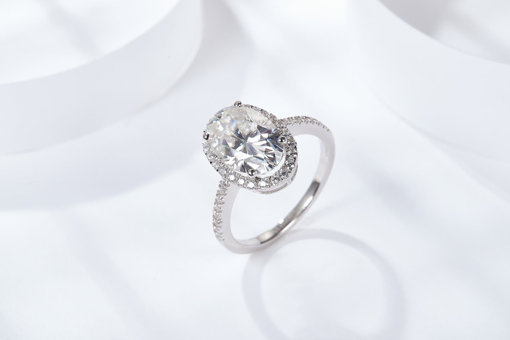 CARISSIE oval moissanite halo ring, three-quarter top angle highlighting stone brilliance against a bright white background