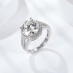 CARISSIE round moissanite pavé ring, lifestyle shot on white surface showing sparkle and prong setting details