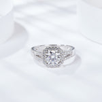 CARISSIE round moissanite halo ring, lifestyle shot on white surface showcasing the full silver-tone silhouette