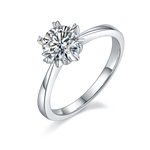 CARISSIE round moissanite solitaire ring, angled view highlighting the unique snowflake prong setting and polished silver band