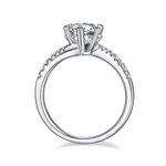 CARISSIE round moissanite solitaire ring, side profile showing the open gallery and pavé stones extending halfway down the band