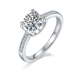 CARISSIE round moissanite solitaire ring, angled view showing brilliant center stone and pavé shoulder details