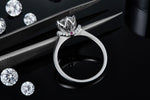 CARISSIE round moissanite solitaire ring, detailed macro shot resting on tweezers to show craftsmanship