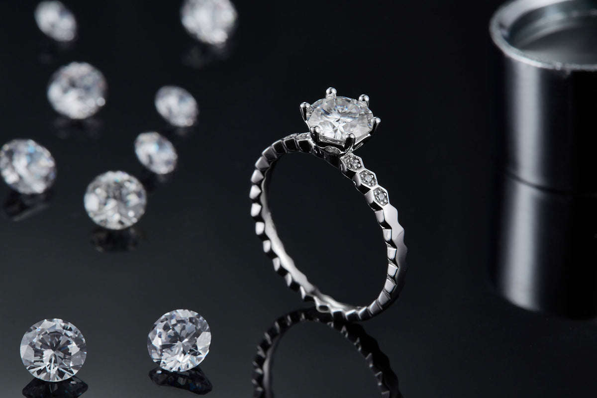 CARISSIE round moissanite solitaire ring, side profile on black background emphasizing the prong height and band facets