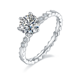 CARISSIE round moissanite solitaire ring, angled view highlighting the geometric honeycomb band and hexagonal side stones