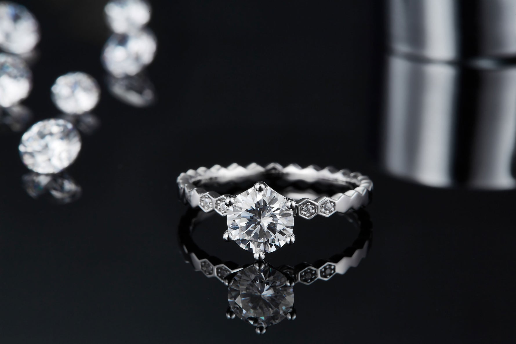 CARISSIE round moissanite solitaire ring, lifestyle shot with reflection showing the center stone brilliance and textured details