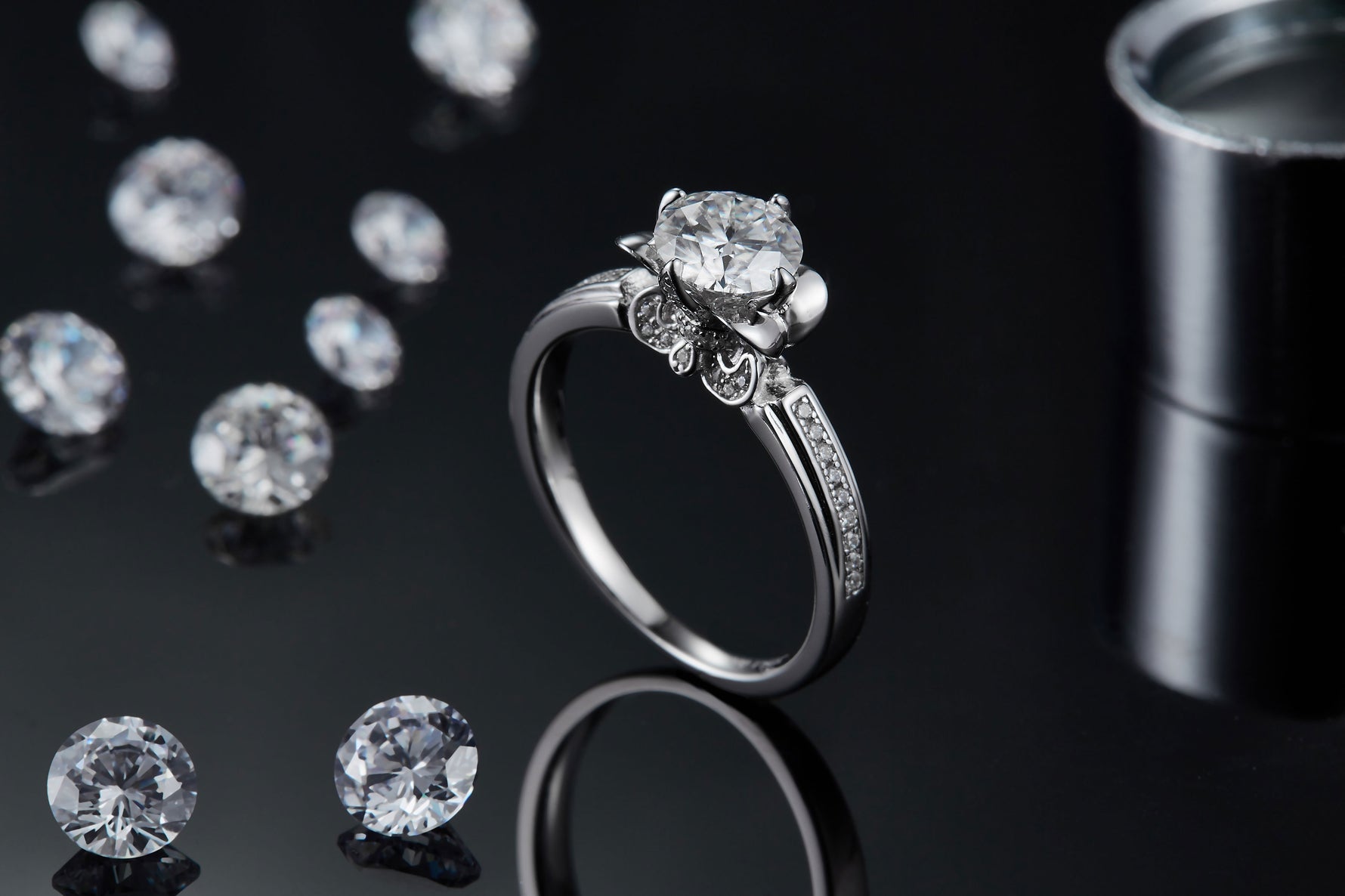 CARISSIE round moissanite solitaire ring, side profile shot on black background displaying the detailed under-gallery design