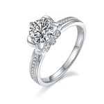 CARISSIE round moissanite solitaire ring, angled view highlighting channel-set shoulder stones and polished silver band
