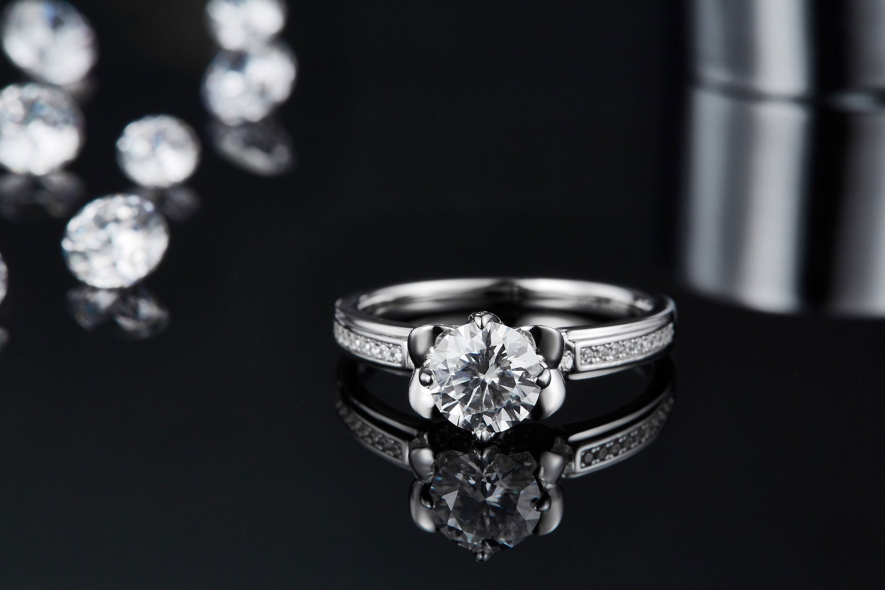 CARISSIE round moissanite solitaire ring, front lifestyle shot with reflection, emphasizing the sparkle of the center stone