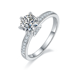 CARISSIE round moissanite solitaire ring, angled view showing six prongs and pavé stones on the V-shaped gallery
