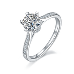 CARISSIE round moissanite solitaire ring, angled view highlighting split shank with pave accents and heart-shaped prong tips
