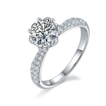 CARISSIE round moissanite solitaire ring, angled view showing floral prongs and pavé band details