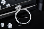 CARISSIE round moissanite solitaire ring, side profile resting on tweezers to show detailed metalwork
