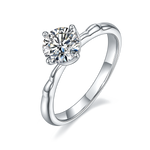 CARISSIE round moissanite solitaire ring, angled view highlighting the organic vine-like texture of the white metal band