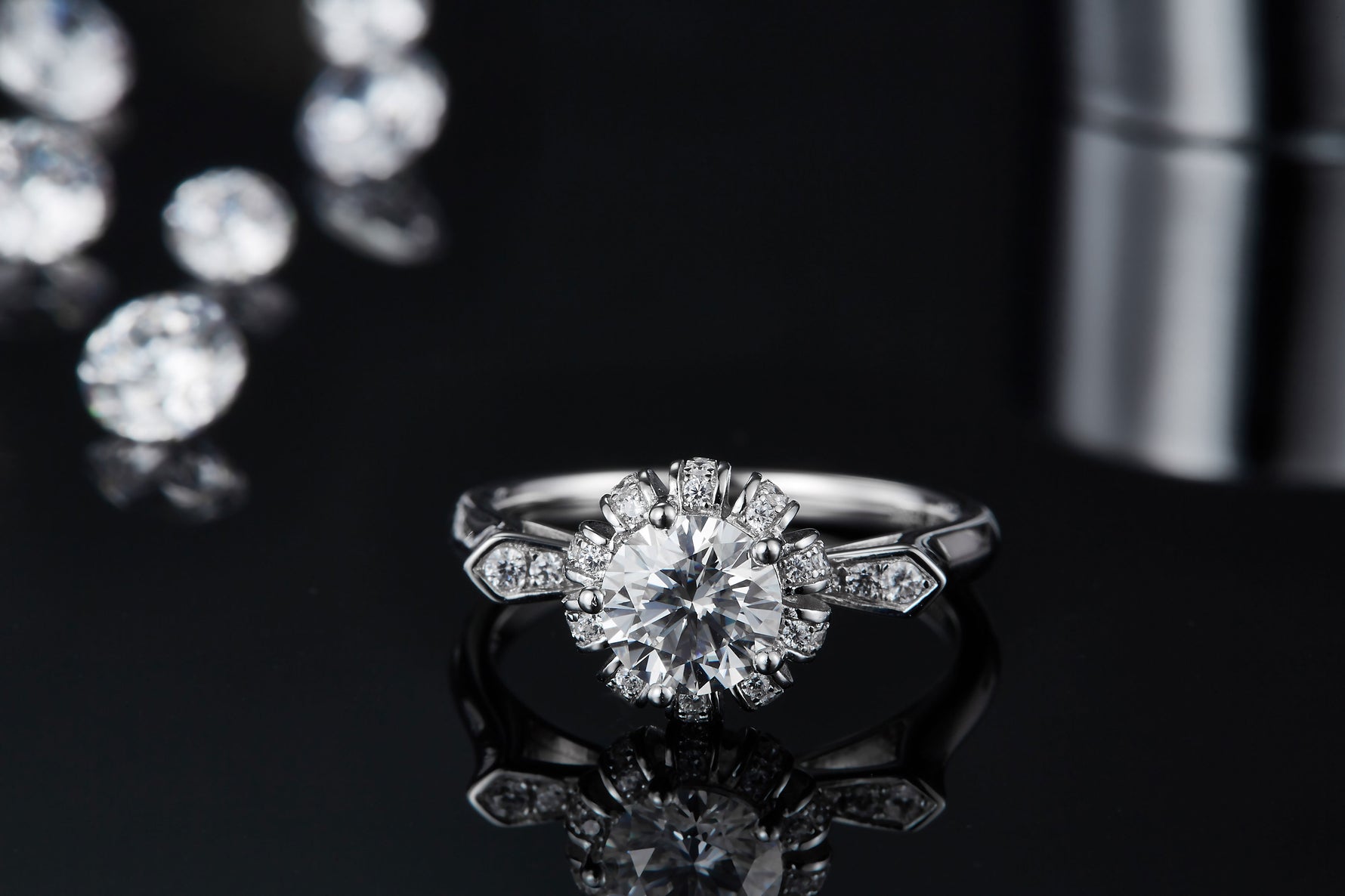 CARISSIE round moissanite halo ring, front-facing reflection on dark background displaying the brilliant sparkle of the center gem