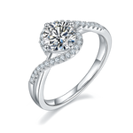 CARISSIE round moissanite solitaire ring, angled view showing bypass band with pavé stones and brilliant center stone