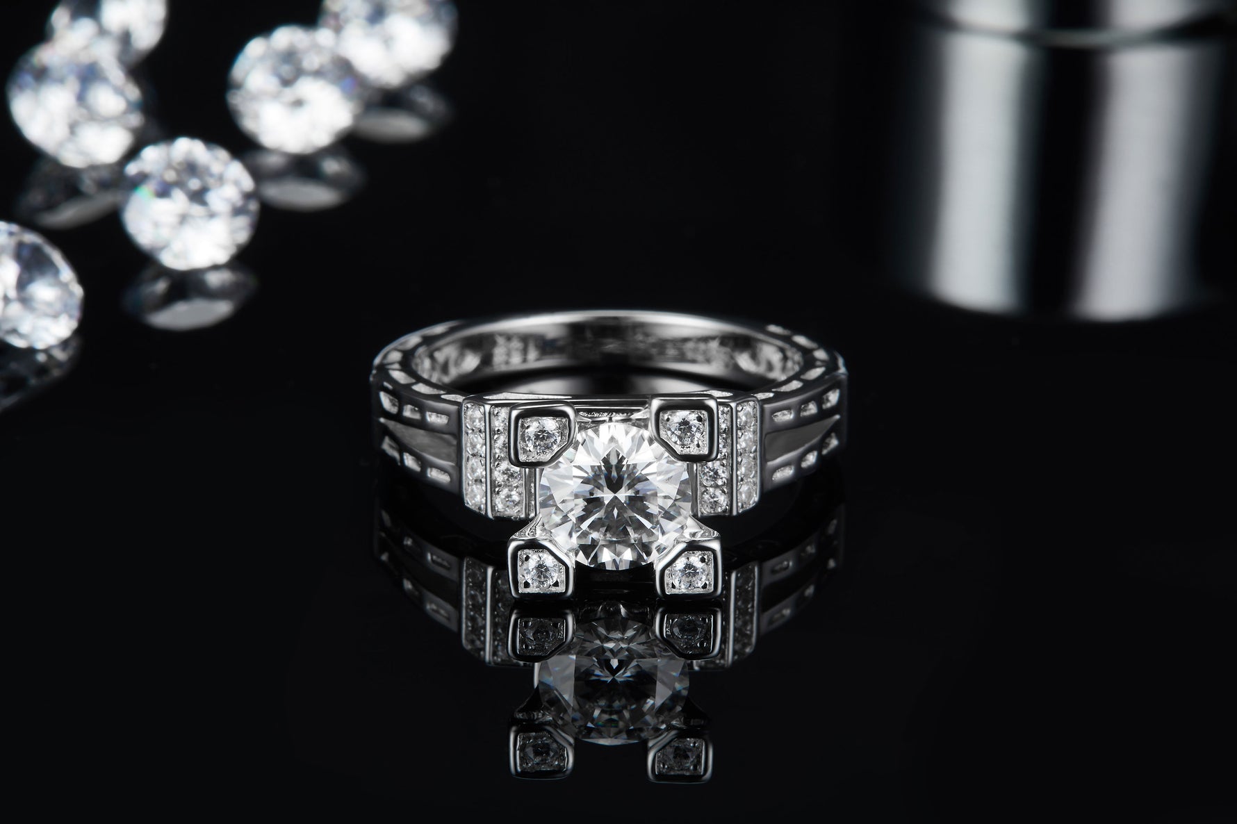 CARISSIE round moissanite solitaire ring, straight-on reflection shot emphasizing symmetry of industrial-style setting and center gem