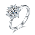 CARISSIE round moissanite cluster ring, angled view highlighting heart-shaped prongs and six surrounding accent stones