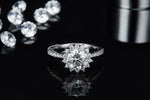 CARISSIE round moissanite halo engagement ring, centered view showing the full sparkle of the silver-tone metal and halo design.